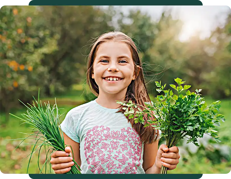 Little girl holding herb bundles in her hands